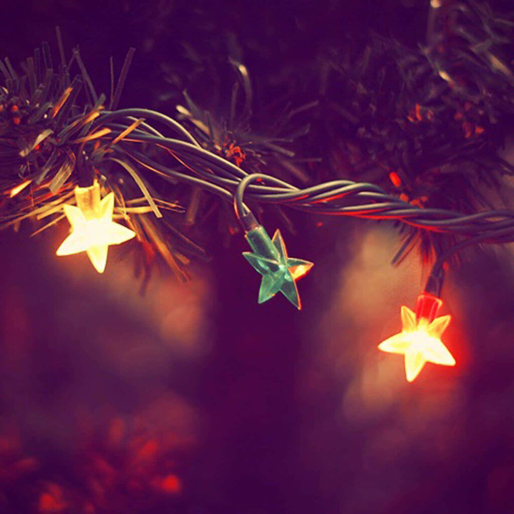 Warm Christmas Wallpaper: Starry Lights & Festive Greenery Background