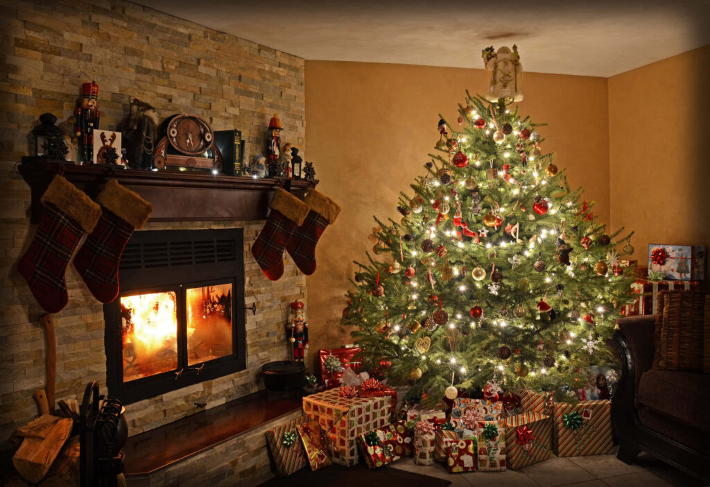Cozy Christmas Scene: Warm Fireplace & Decorated Tree Background Wallpaper