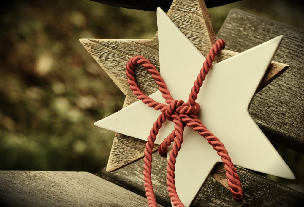 Cozy Christmas Wallpaper: White Star & Red Rope on Rustic Wood