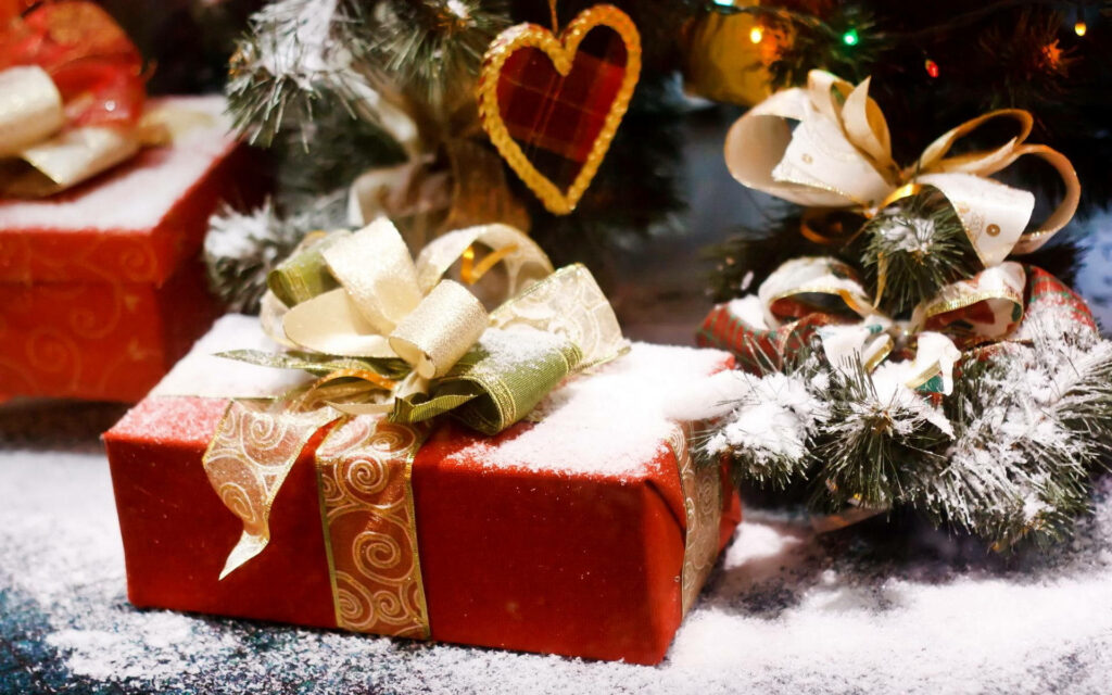 Cozy Christmas with Elegant Gifts & Snowy Pine Background Wallpaper