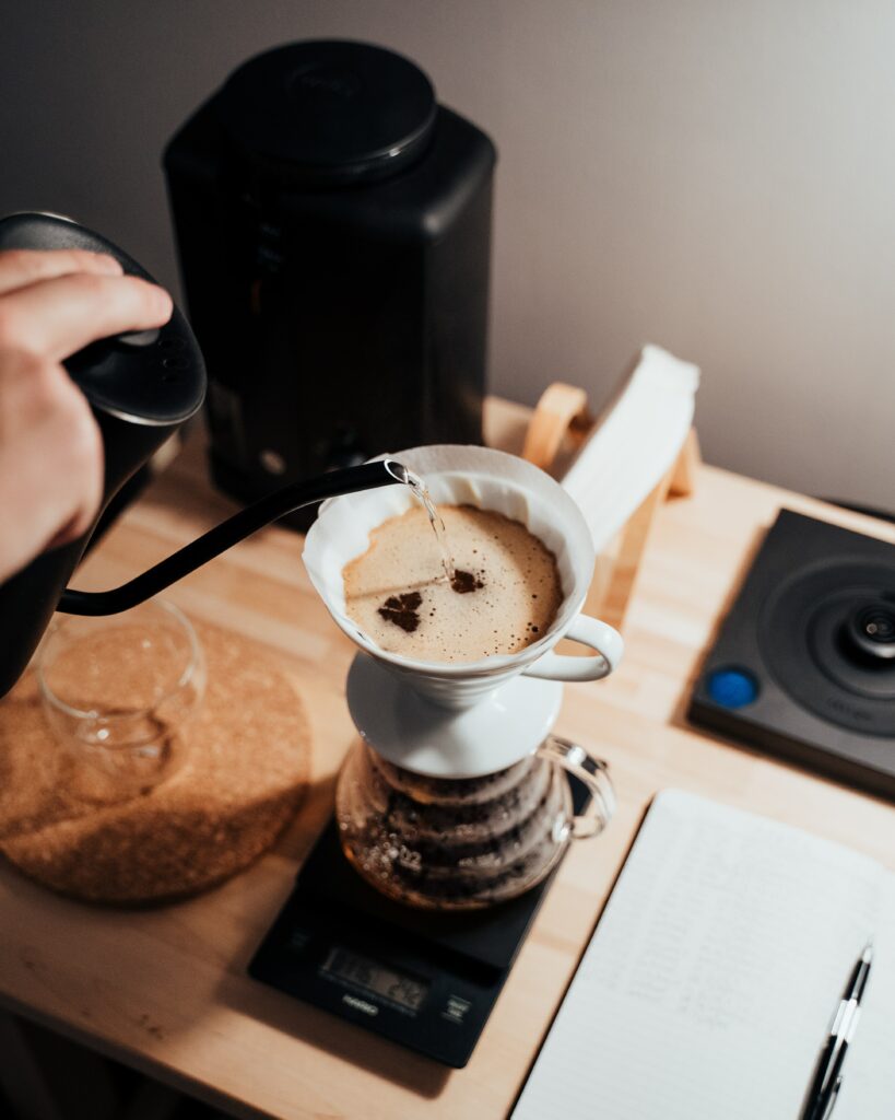 Cozy Coffee Setup: Hand-Poured Brew on Minimalist Wooden Table Wallpaper