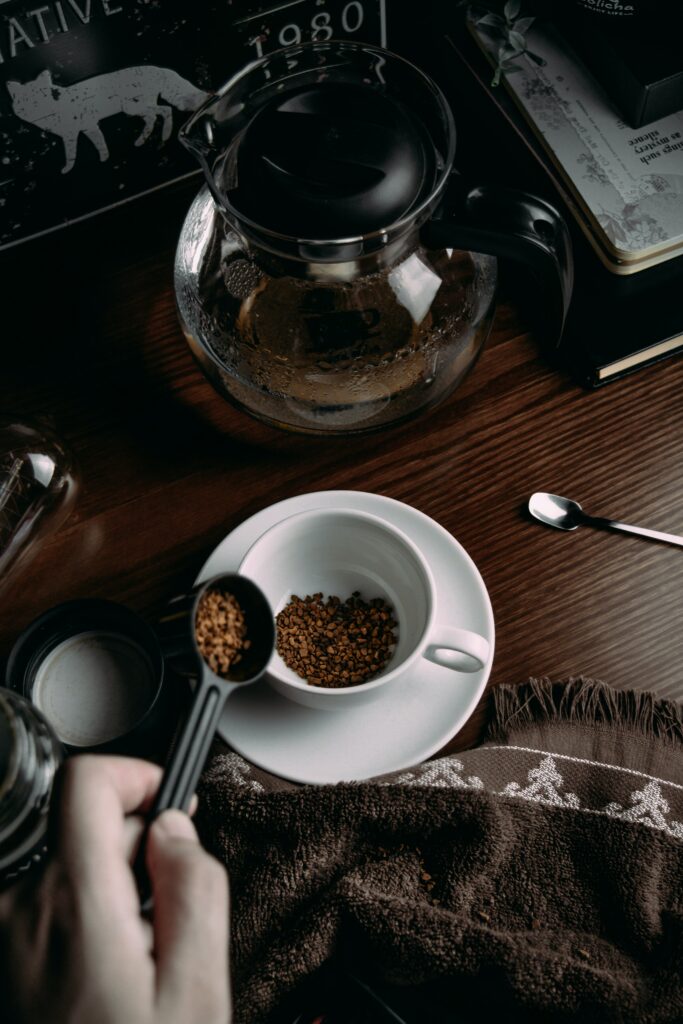 Cozy Coffee Setup: White Mug, Spoon & Kettle on Warm Textured Cloth Wallpaper