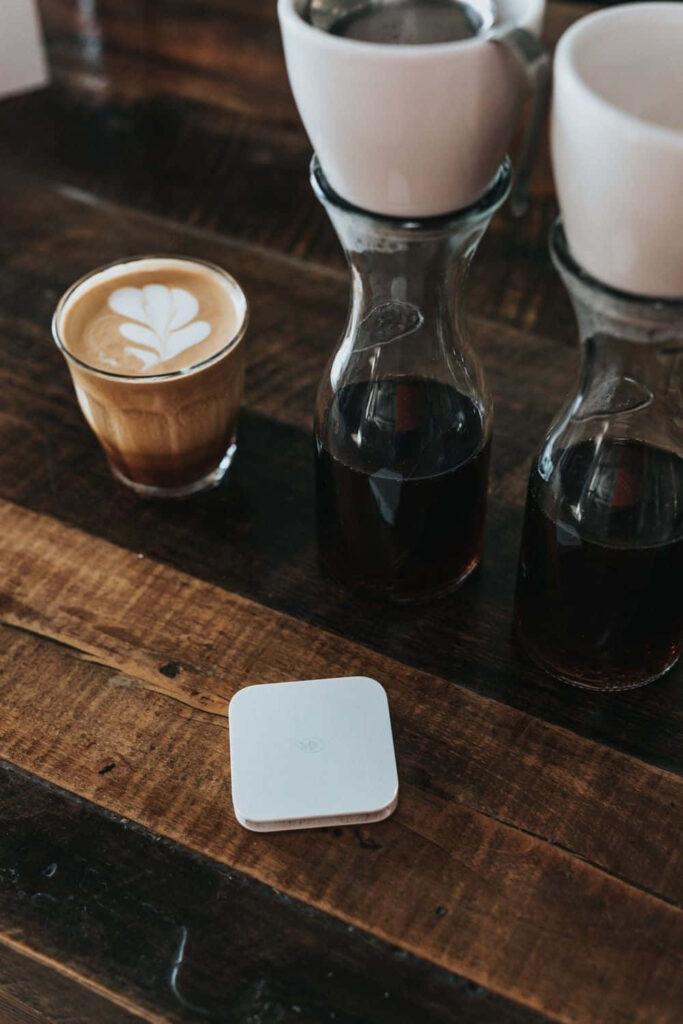 Cozy coffee setup with fresh black coffee in glass carafes and latte on rustic wooden table Wallpaper