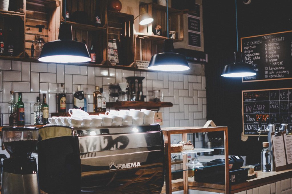 Cozy coffee shop wallpaper with FAEMA espresso machine rustic subway tiles warm pendant lights
