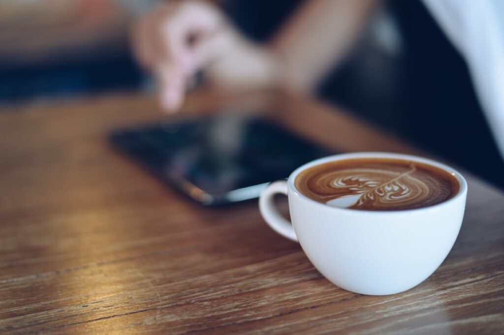 Warm Coffee Wallpaper: Inviting Latte Art on Wooden Table