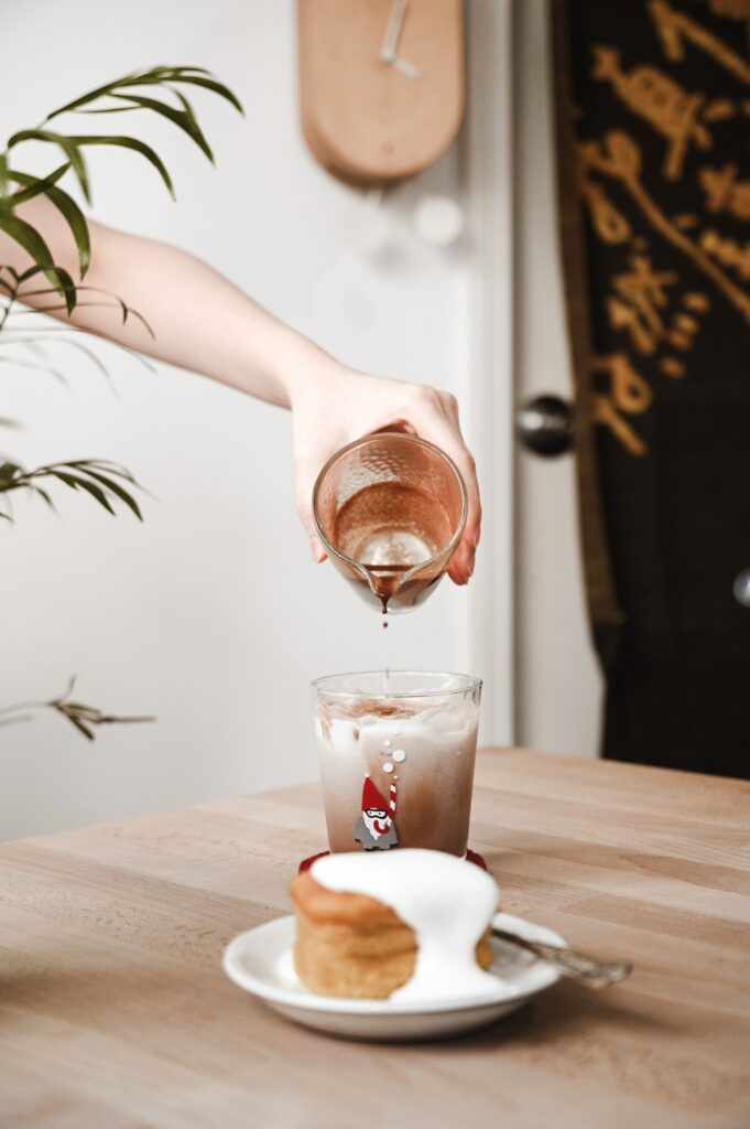 Cozy Coffee & Cake Setup: Iced Drink and Cake on Wooden Table Wallpaper