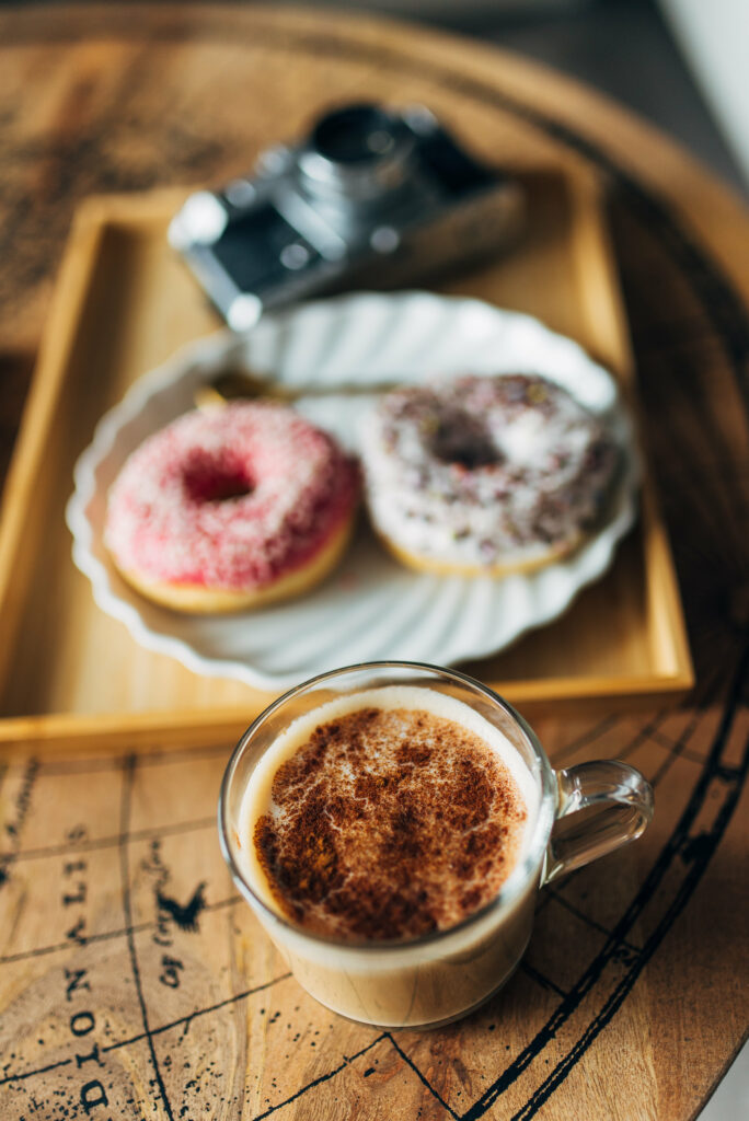 Cozy Coffee & Donuts: Vintage Camera on a Wooden Table Wallpaper