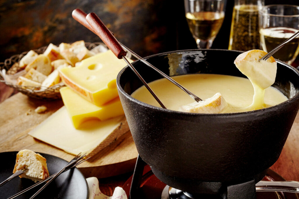 Cozy Cheese Fondue Setup: Black Pot & Bread Dipping Delight Wallpaper