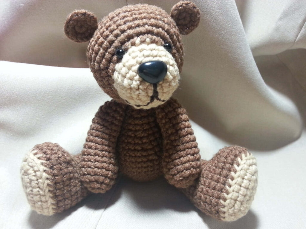 Cozy Crocheted Teddy Bear Wallpaper: Handmade Charm in Warm Tones
