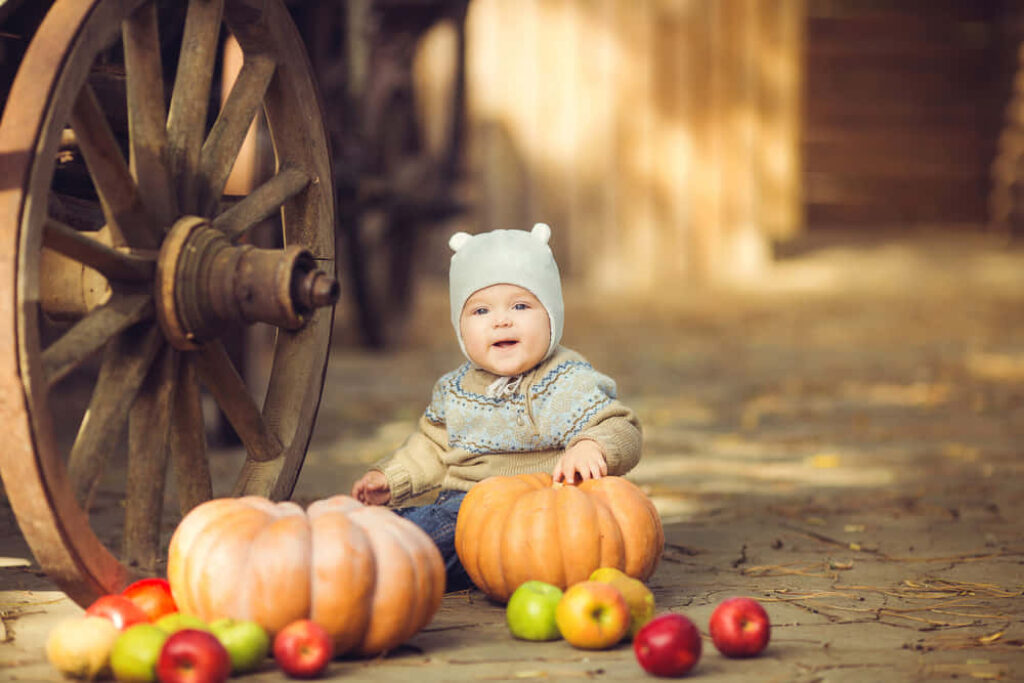 Cozy Fall Wallpaper: Smiling Baby with Pumpkins & Apples