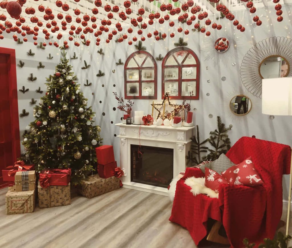 Festive Christmas background with decorated tree red armchair and classic white fireplace holiday wallpaper