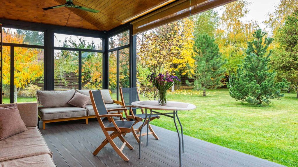 Cozy rear porch wallpaper with gray sofa bistro set autumn garden view bright natural light