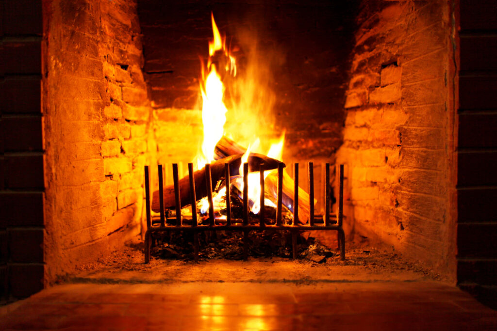 Cozy glowing fireplace with crackling logs creating warm inviting atmosphere wallpaper background