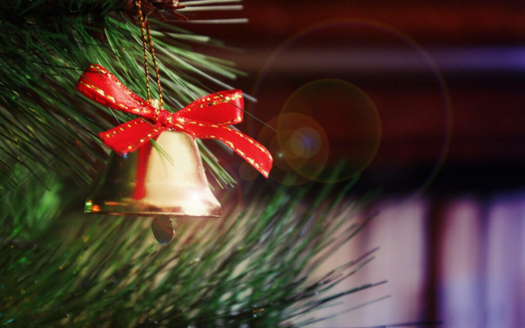 Festive Gold Christmas Bell Wallpaper with Red Ribbon & Pine Branch