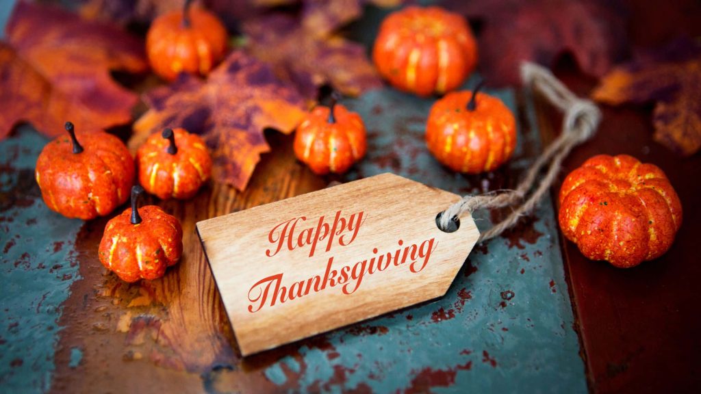 Cozy Happy Thanksgiving wallpaper with rustic wooden tag pumpkins and autumn leaves background