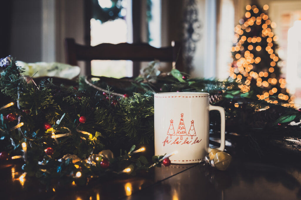Cozy Holiday Wallpaper: Mug & Garland Scene with Christmas Tree