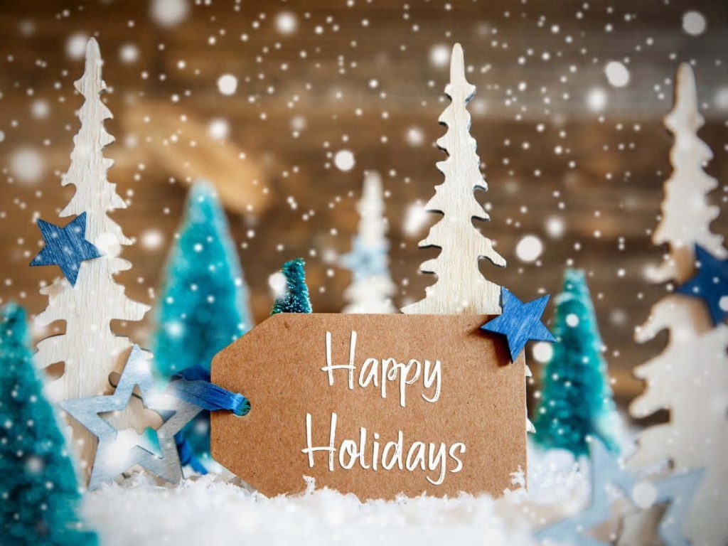 Festive holiday wallpaper with rustic Happy Holidays tag snow wooden trees blue stars cozy lights