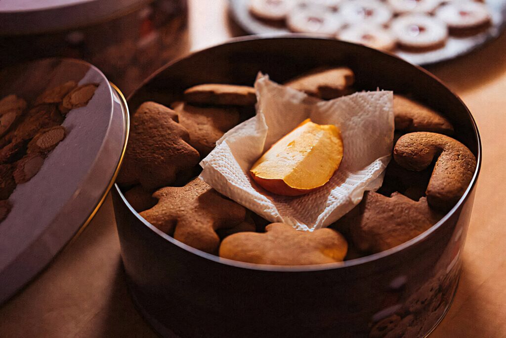 Cozy wallpaper of homemade gingerbread and butter cookies in rustic tin with warm lighting