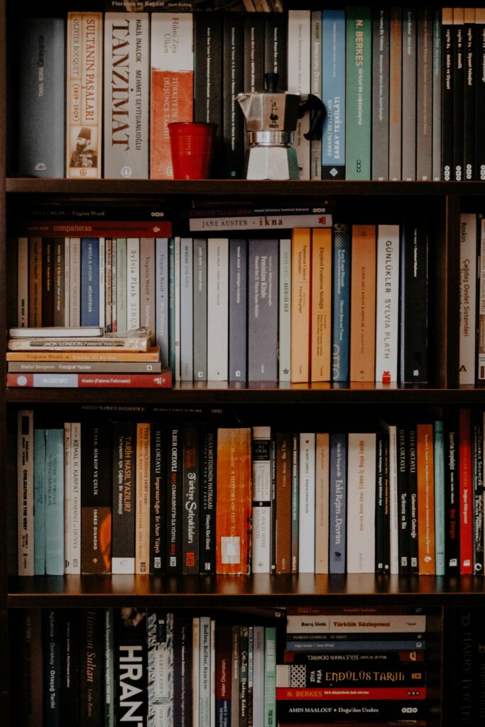 Cozy library wallpaper with dark wooden shelves books metallic teapot glass warm atmosphere