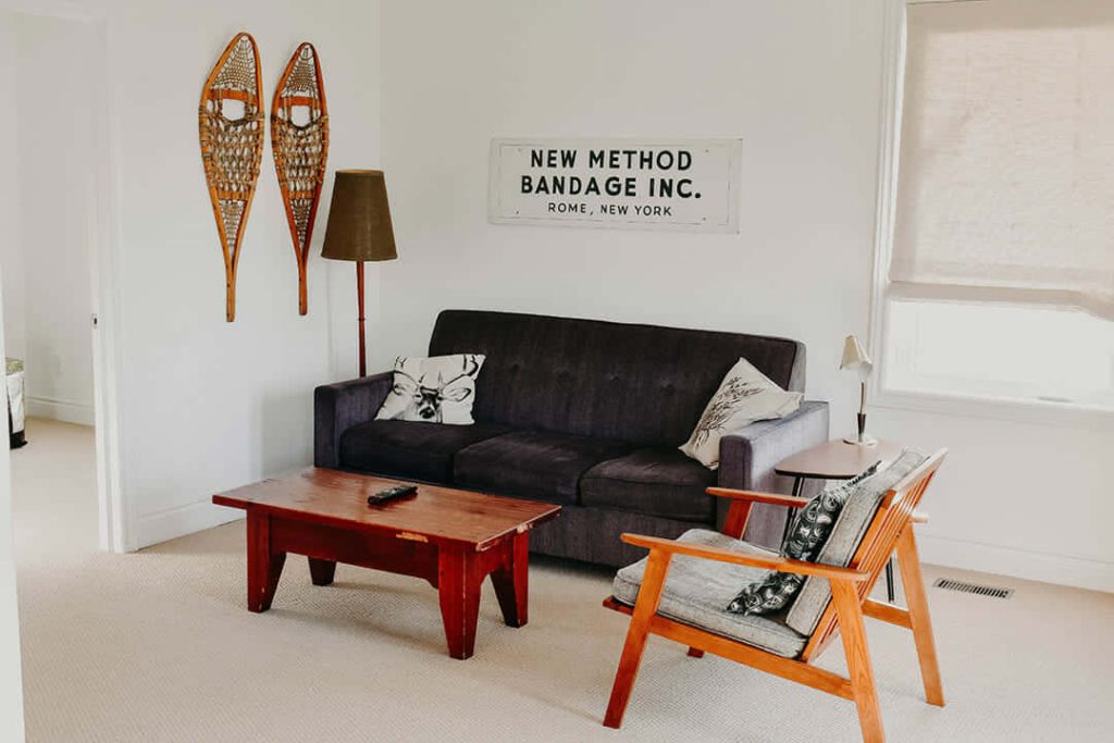 Cozy living room Zoom background with dark grey couch rustic coffee table and vintage decor Wallpaper