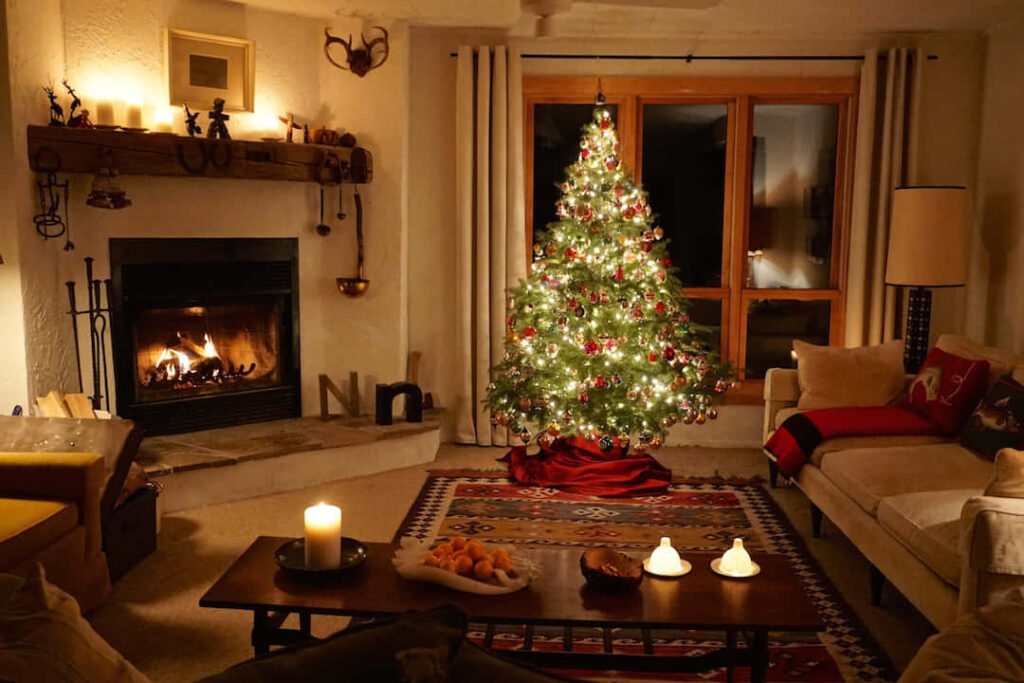 Cozy Christmas Living Room with Twinkling Tree & Warm Fireplace Glow Wallpaper