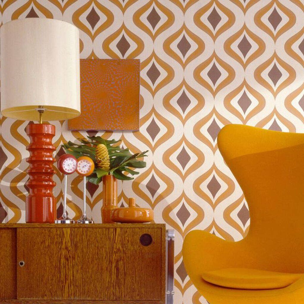 Mid-century modern sitting room with geometric tan wallpaper mustard egg chair wooden cabinet and orange lamp
