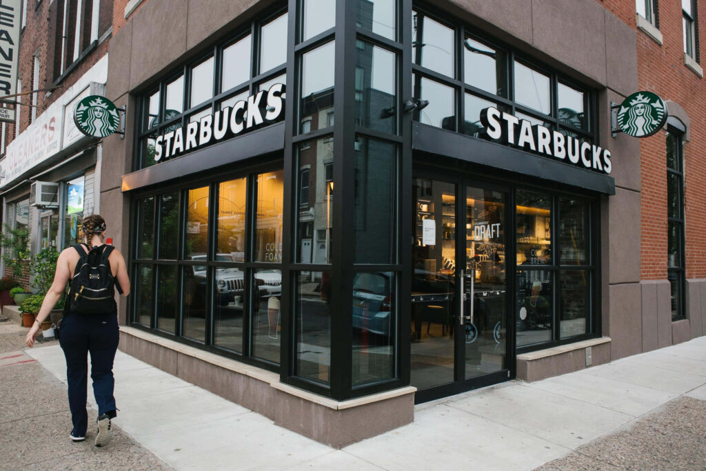Modern Starbucks storefront with cozy urban seating inviting customers to enjoy a latte Wallpaper