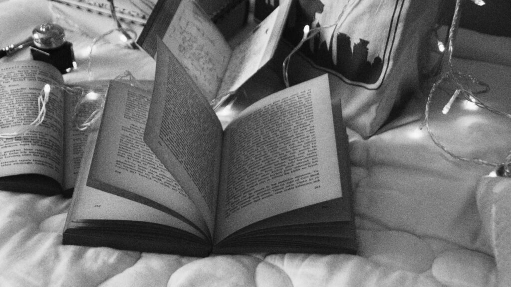 Cozy Monochrome Wallpaper: Open Book with Fairy Lights Background