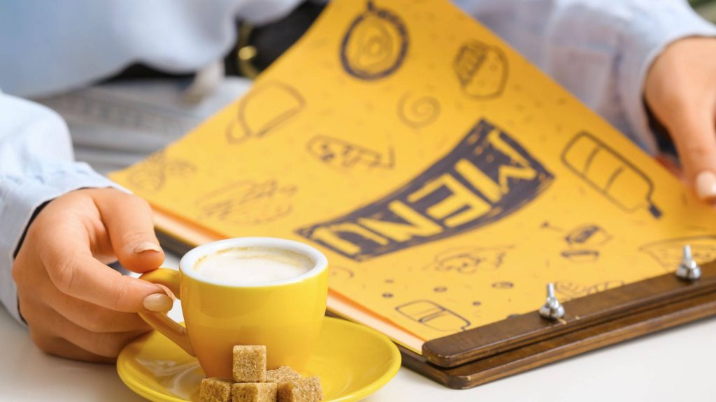 Cozy morning coffee scene with yellow cup sugar cubes and restaurant menu on clipboard wallpaper