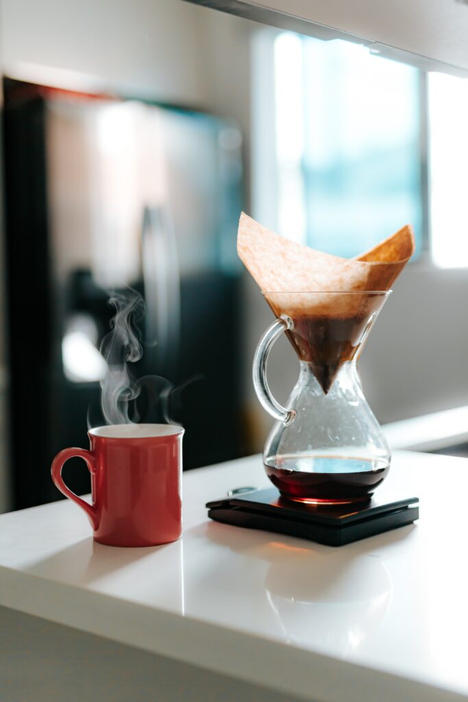 Cozy Morning: Steaming Coffee & Chemex Maker on Bright Kitchen Counter Wallpaper