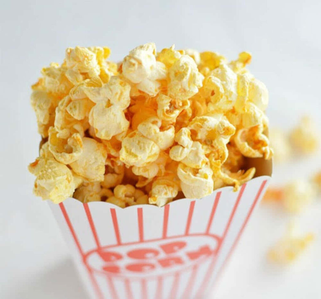 Cozy Movie Night: Striped Popcorn Box Overflows with Buttery Goodness Wallpaper