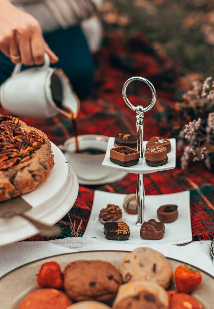 Cozy Picnic Setup: Sweets, Tea, and Vibrant Plaid Blanket Wallpaper