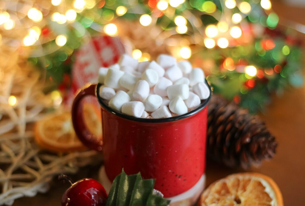 Cozy Red Mug with Marshmallows Amidst Festive Holiday Decor Wallpaper