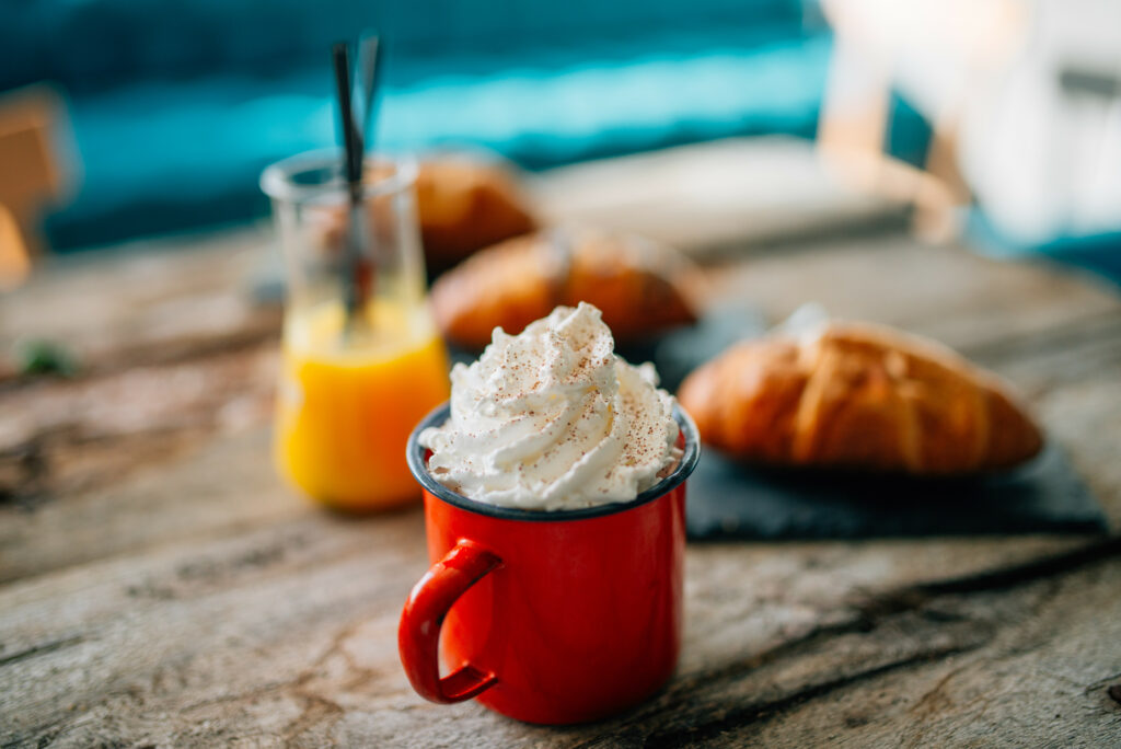 Cozy Setup: Red Mug with Whipped Cream & Croissants Wallpaper