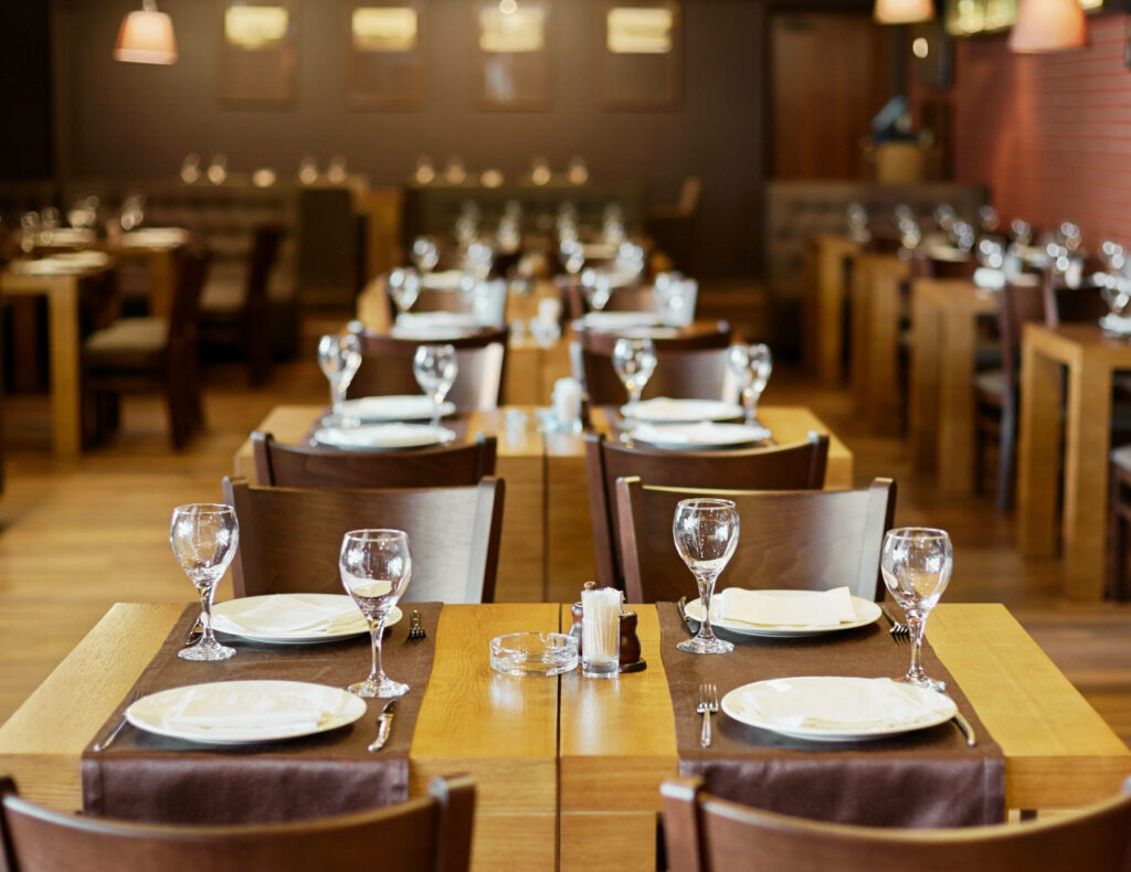 Charming Restaurant Ambiance: Cozy Wooden Tables & Cozy Decor Wallpaper