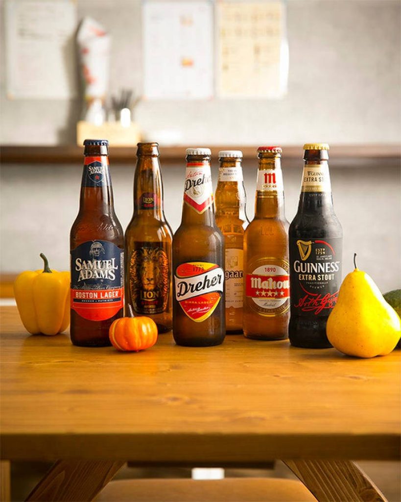 Rustic cozy beer collection with Samuel Adams Lion Dreher Mahou Guinness and autumn fruits Wallpaper