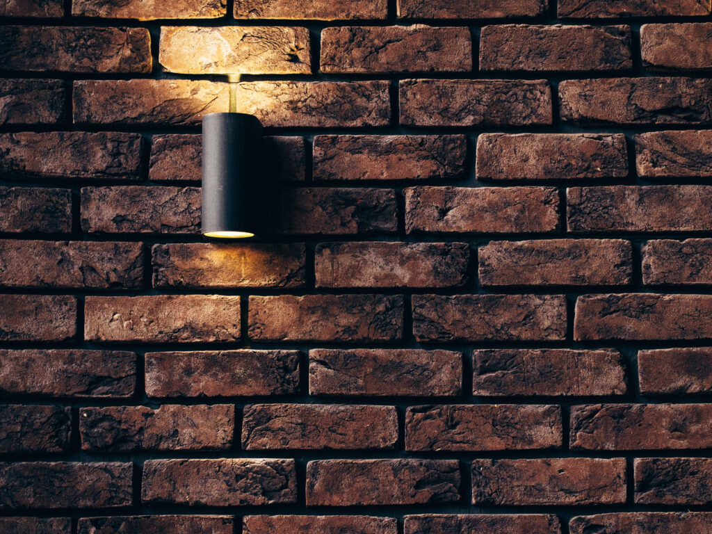 Cozy Industrial Brick Wall Wallpaper with Warm Light Fixture