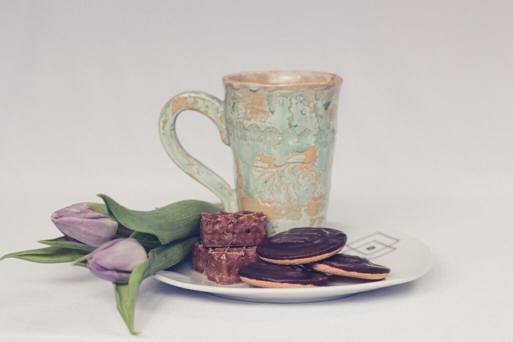 Rustic Ceramic Cup with Cookies & Cakes and Purple Tulips Wallpaper