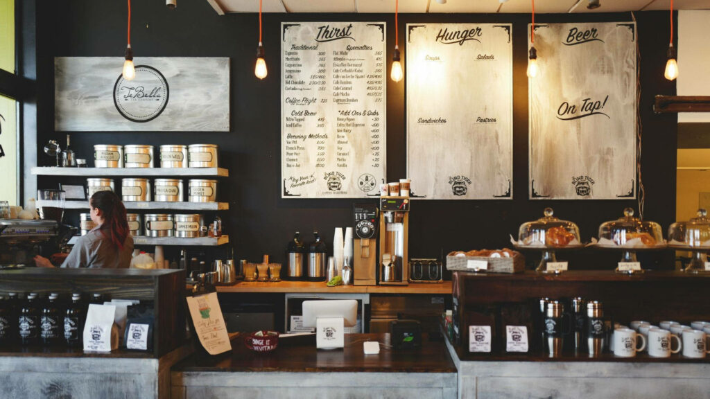 Cozy rustic coffee shop wallpaper with jars coffee machines handwritten menus and warm lighting