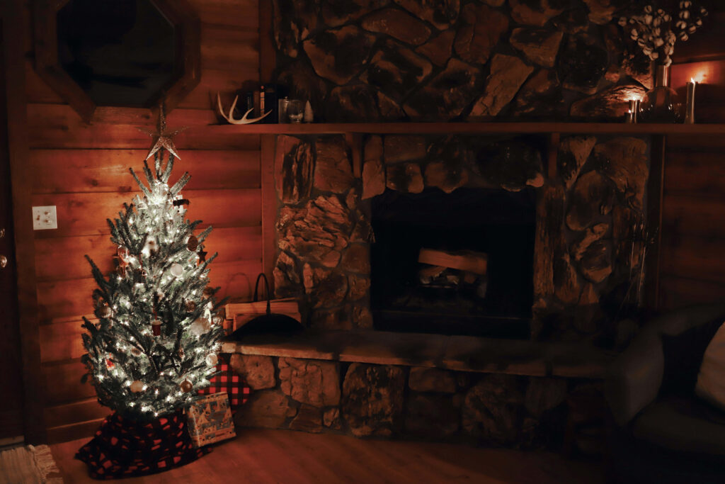 Cozy Rustic Fireplace and Glowing Christmas Tree Scene Background Wallpaper