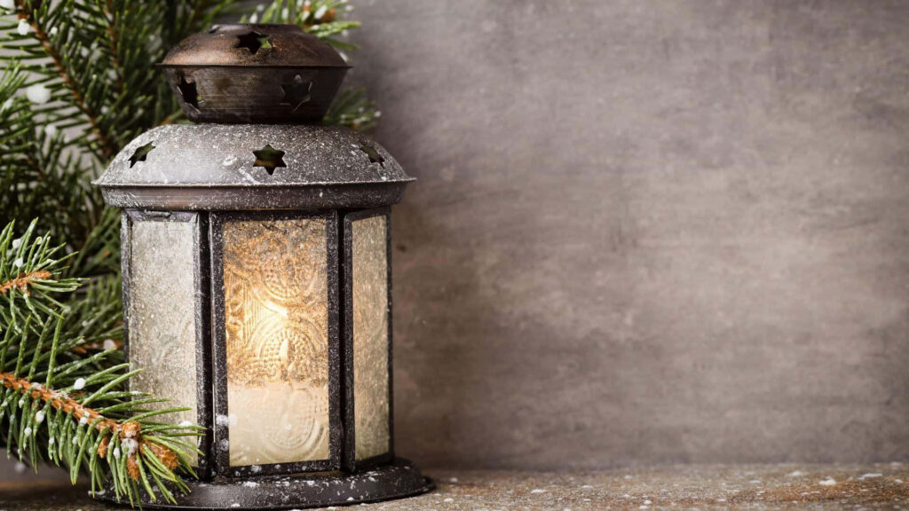 Cozy Rustic Lantern with Candle and Pine Background Holiday Decor Wallpaper