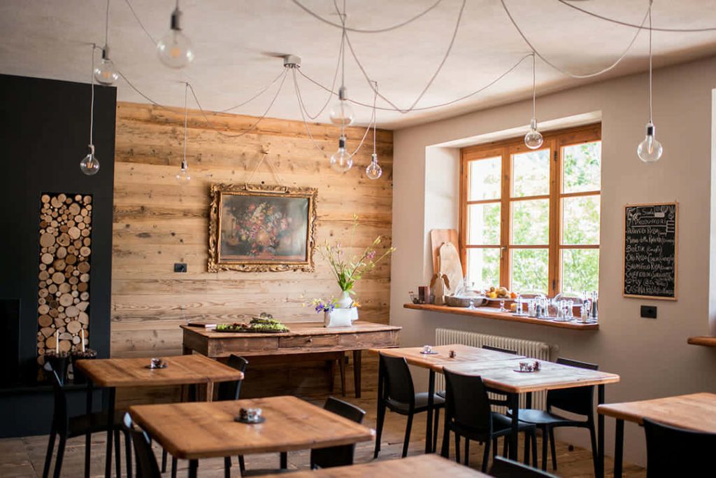 Cozy rustic restaurant interior with wooden walls Edison bulbs and floral art virtual zoom background Wallpaper