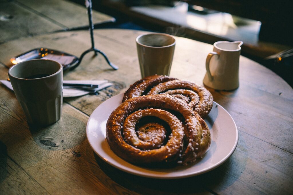 Cozy Spiral Pastries & Coffee on Rustic Table - Warm Decor Vibes Wallpaper