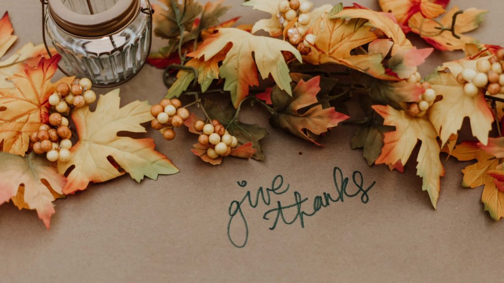 Rustic Thanksgiving flat lay with autumn leaves cream berries glass lantern handwritten give thanks Wallpaper