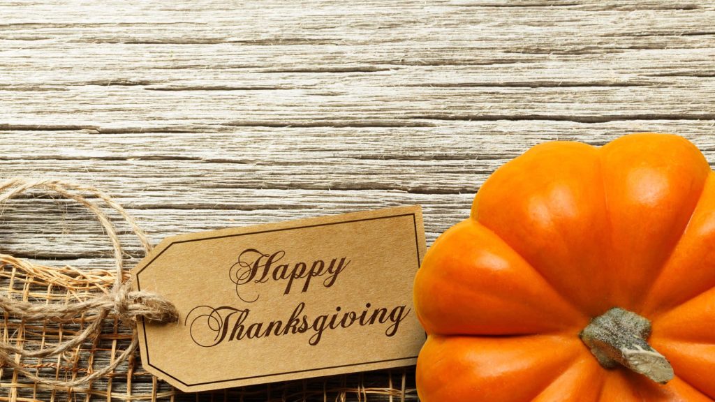 Rustic Thanksgiving wallpaper with orange pumpkin and Happy Thanksgiving tag on wood background