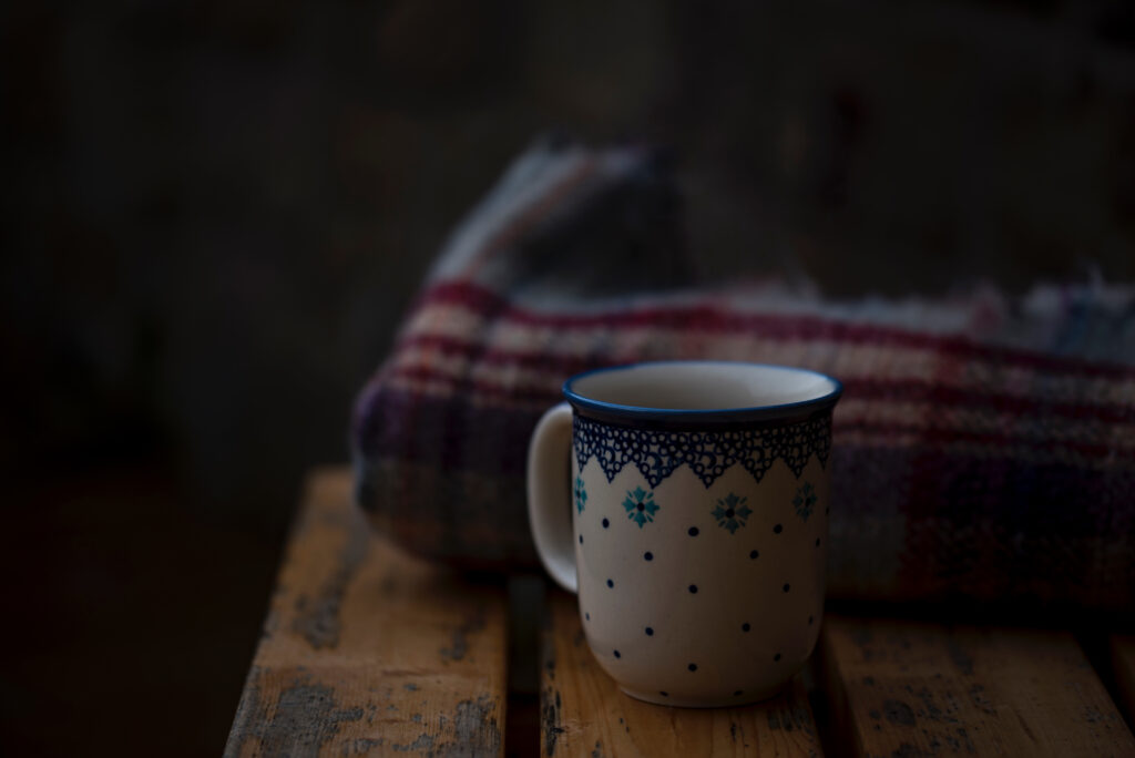 Cozy Rustic Wallpaper: Patterned Cup on Wooden Bench with Plaid