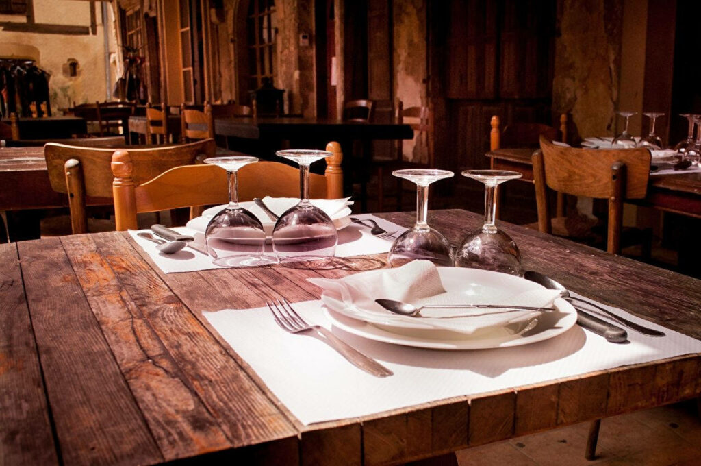Elegant Semi-Formal Table Setting in Cozy Restaurant Wallpaper