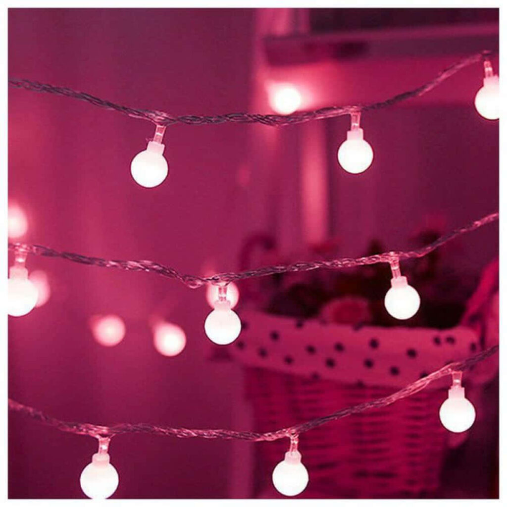 Soft pink string lights with glowing round bulbs creating warm cozy ambiance wallpaper background