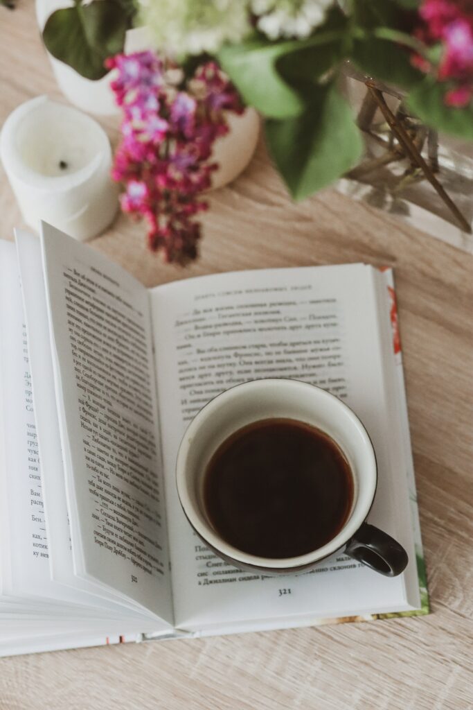 Cozy Still Life: Book, Coffee & Flowers on Wooden Background Wallpaper