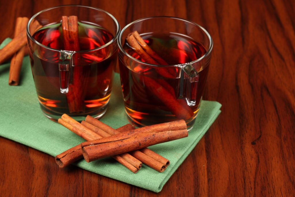 Cozy Tea Scene: Glass Cups with Cinnamon on Wooden Background Wallpaper